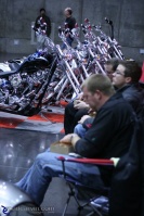 Dining on Custom Harley Row: Booth workers chow down on lunch.  In the background: a row of Harley-Davidson custom bikes.